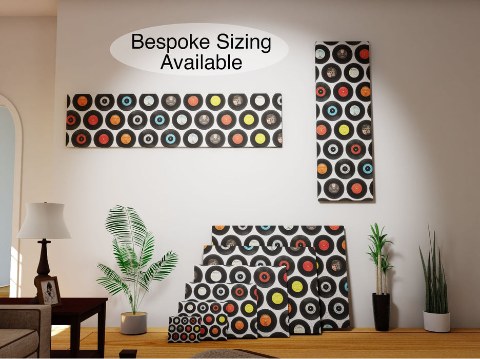 multiple  canvas prints of a mosaic of 7 inch vinyl records,  each canvas of different size, leaning against a wall in a living room with two canvas sizes on the wall