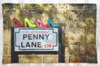 a fleece blanket laid on a woodern floor, the blanket having an image of the penny lane street sign with four coloured shoes on the top and also a personal message printed
