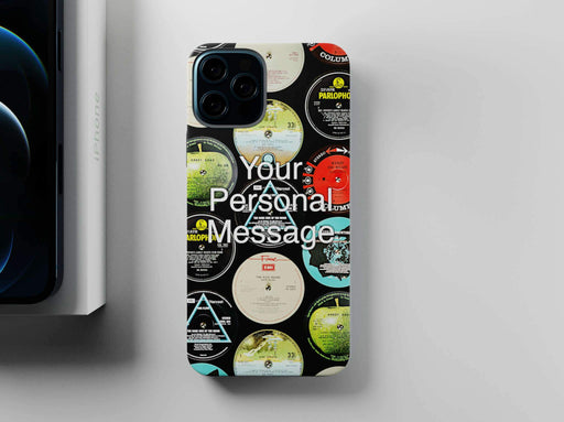 mobile phone cover with vinyl record labels printed in a mosaic pattern, along with a personal message, seen from overhead and sited next to a partially visiable iphone