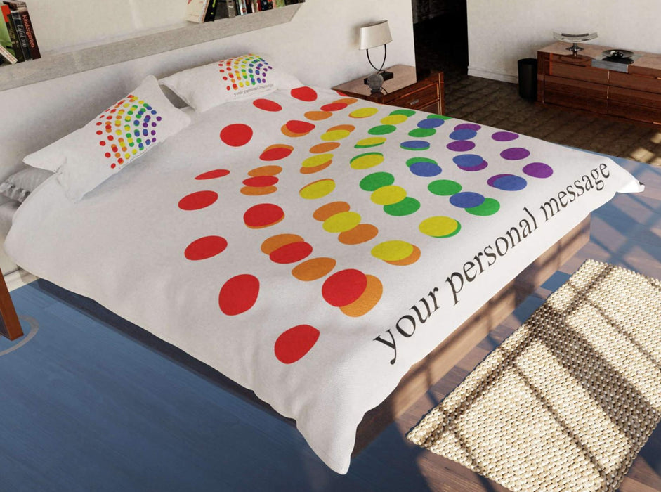 a duvet and pillow set on a bed, featuring multicoloured polka dots in a rainbow pattern, the dots being the colours of the rainbow, with a personalised message also printed, and seen from high and left of the bed