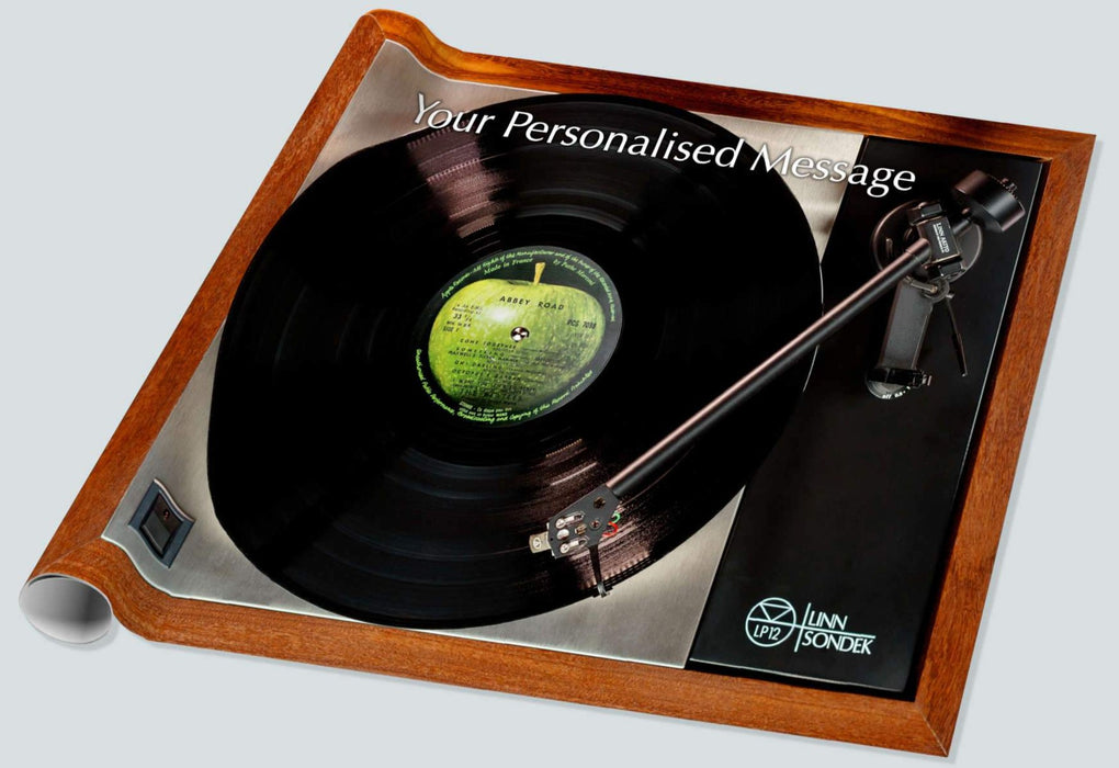 A roll of wrapping paper with mosaic of vinyl record players, large sized image, with a record label with a green apple and a personal message