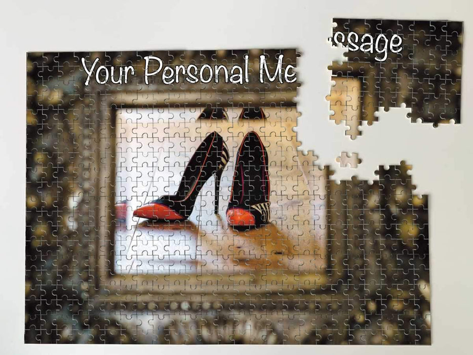 A jigsaw with an image of a pair of orange and black high heel shoes reflected in a brass mirror, along with a printed personal message, the jigsaw is partially dismantled