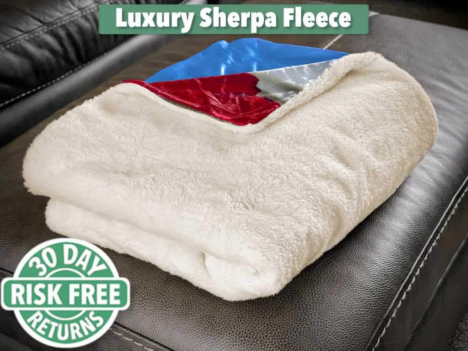 A sherpa fleece blanked folded up and sat on a couch