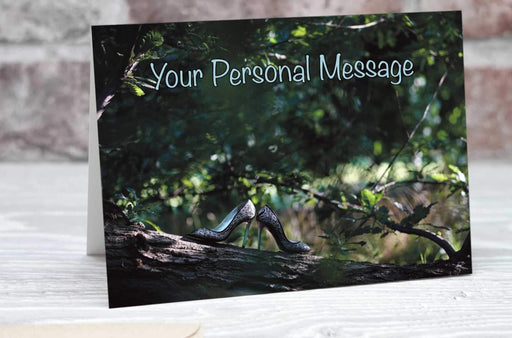 A greetings or birthday card showing a pair of shoes resting on a branch of a tree, the tree being in a forrest and there are other trees in the background, along with a personal message on the card