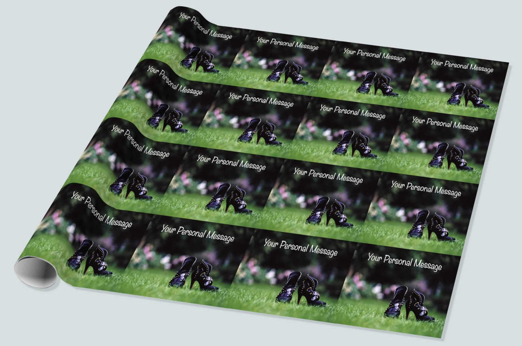 A roll of wrapping paper showing a close up of pair of high heeled purple ankle boots on grass in a garden, with faint images of flowers in the background along with a personal message, the image is then repeated
