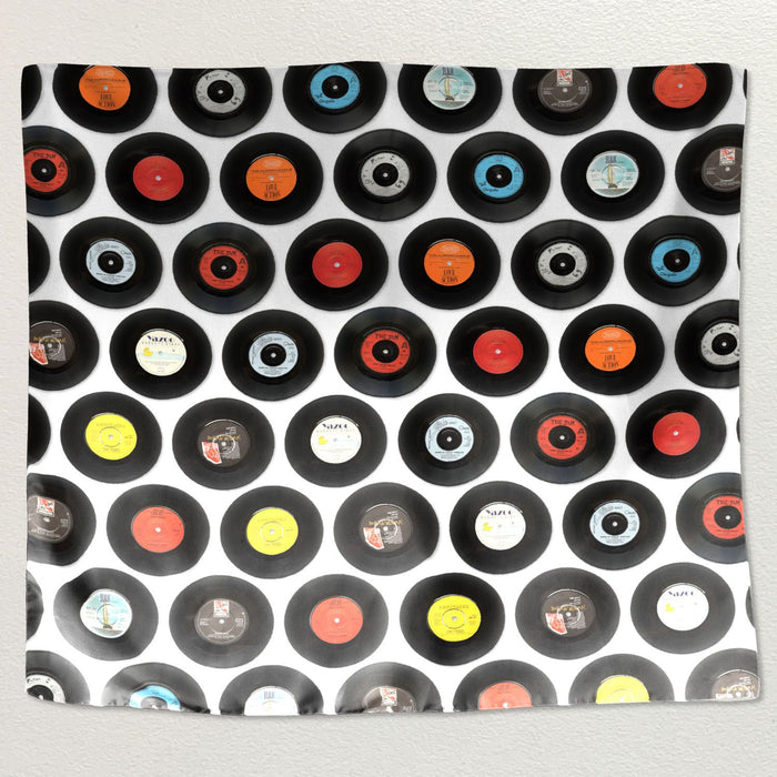 A montage of vinyl reclrds printed on a tapestry wall hanging fabric, the tapestry hung on a white wall