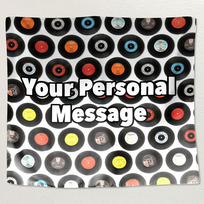 A montage of vinyl reclrds printed on a tapestry wall hanging fabric, the tapestry hung on a white wall along with a personal message