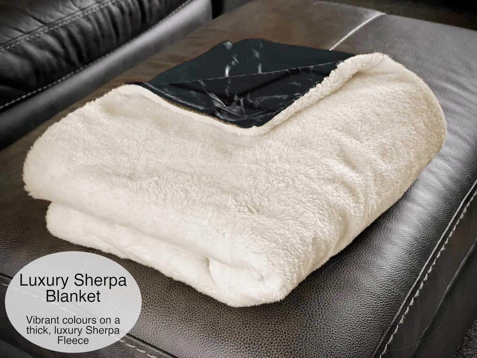 A white sherpa blanket folded showing the white underside and a corner of the upside