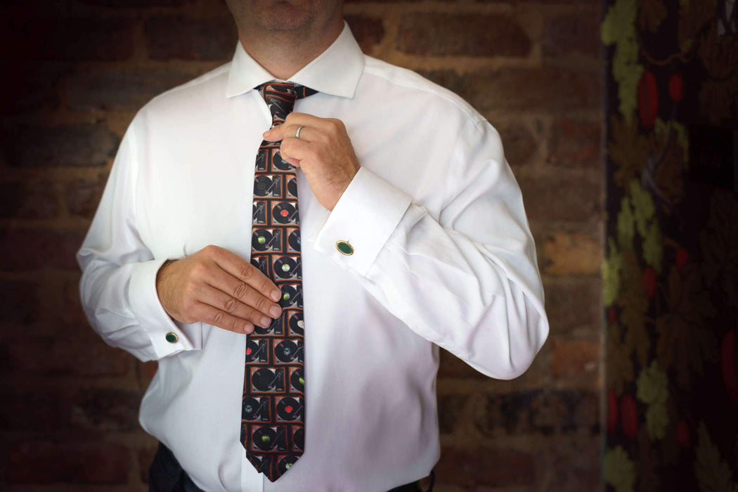 a man in a white shirt wearing neck tie showing a montage of record players on the tie