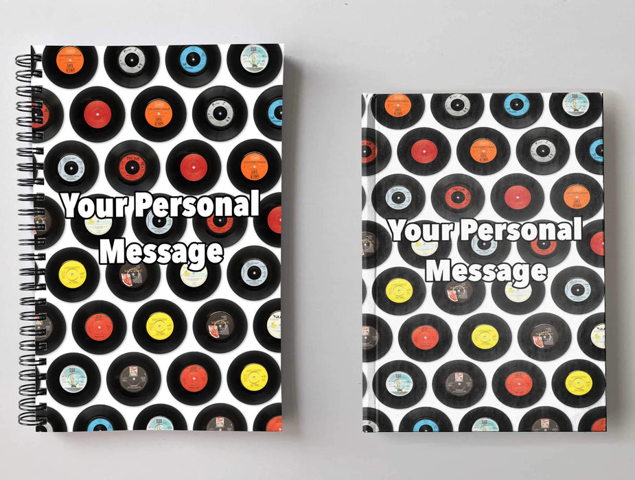 Two notebooks side by side, one a spiral bound and one a hard back, both having front covers with a mosaic of seven inch vinyl records on a white background with a personal message printed on the books